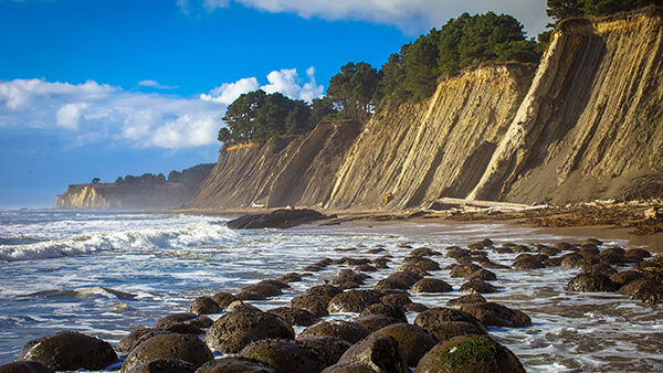 A cliff runs along a rocky shoreline