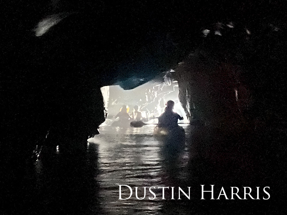 kayakers paddle in the dark through a cave