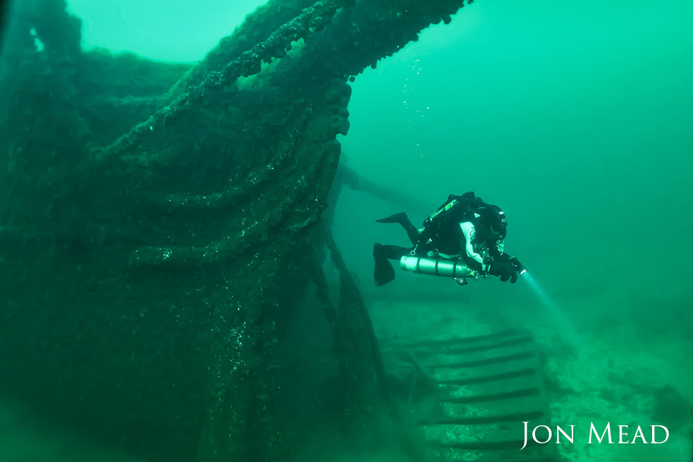 a diver next to a shipwreck