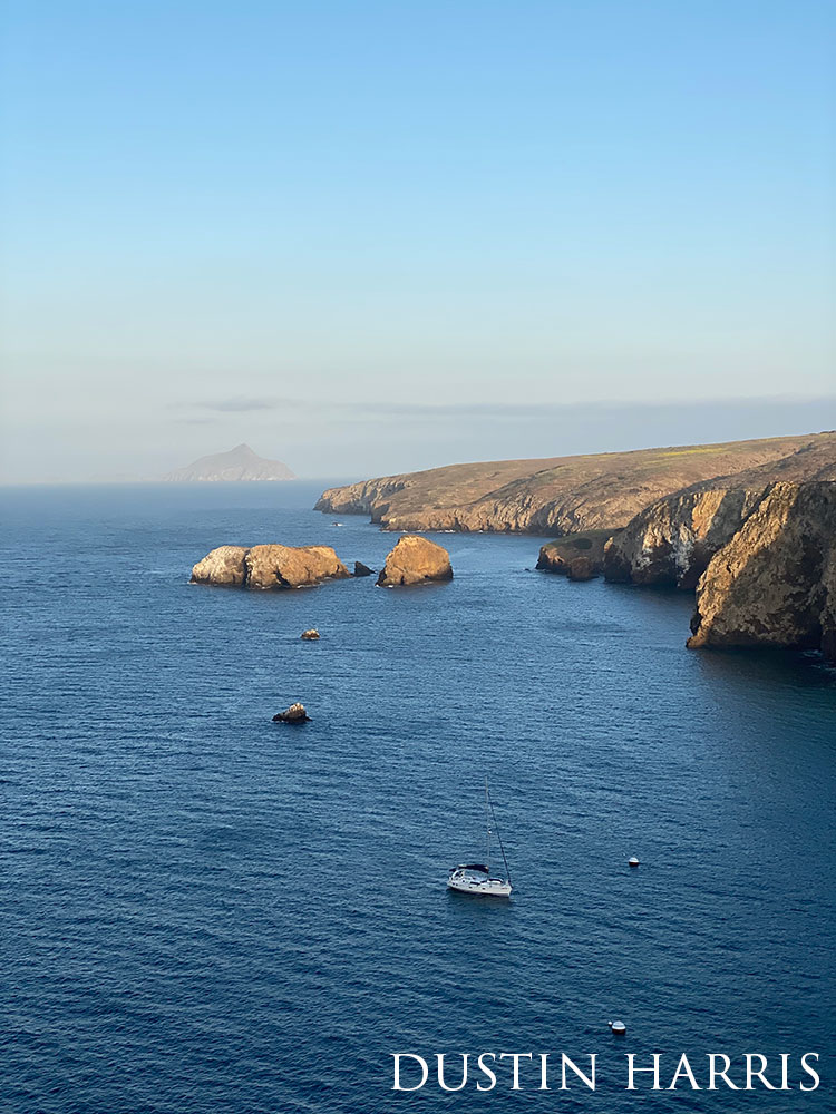 an above view of rocky cliffsides and blue ocean