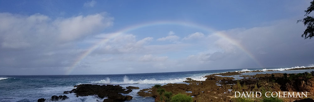rainbow arch over the ocean, on the coast.