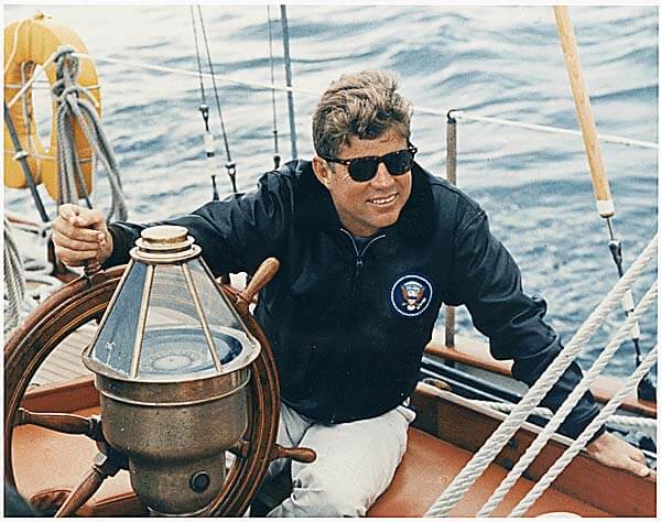 President Kennedy grabbing the wheel of a boat