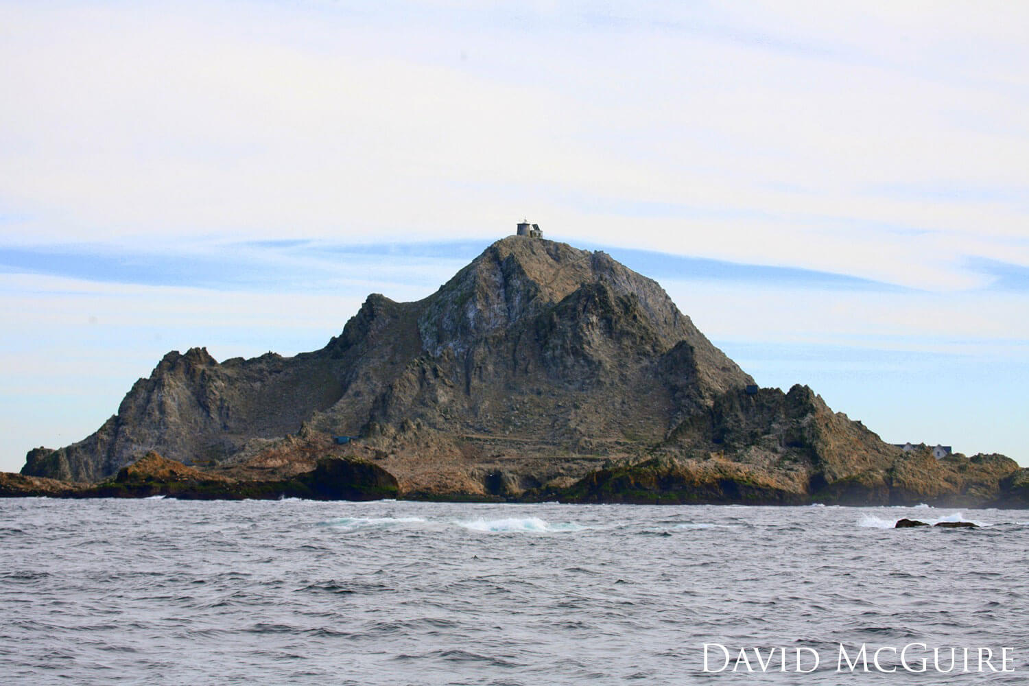 Lighthouse atop a rocky island.