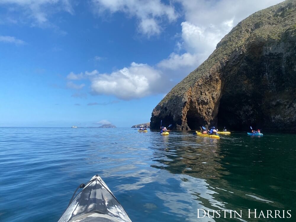 A group of paddlers navigate the rugged cliff sides of Santa Cruz Island.