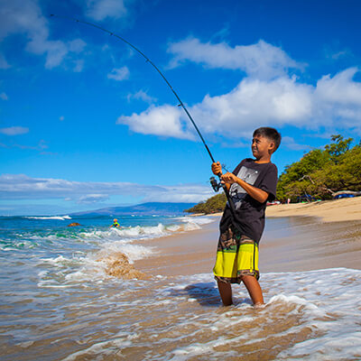 a boy fishing on a beach