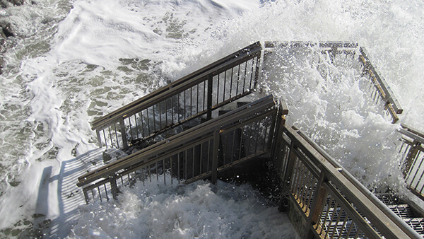 waves crash over a staircase