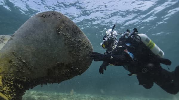 A diver touching the engine of a shipwreck