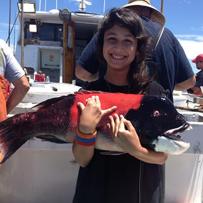 a girl holds a black and red fish