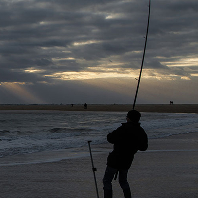 a person fishes from a beach