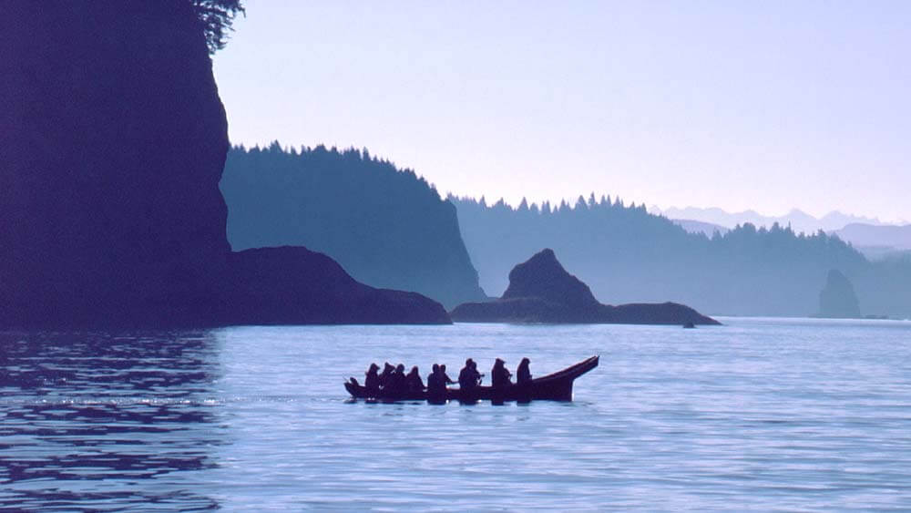 a silhouette of people in a canoe on the water