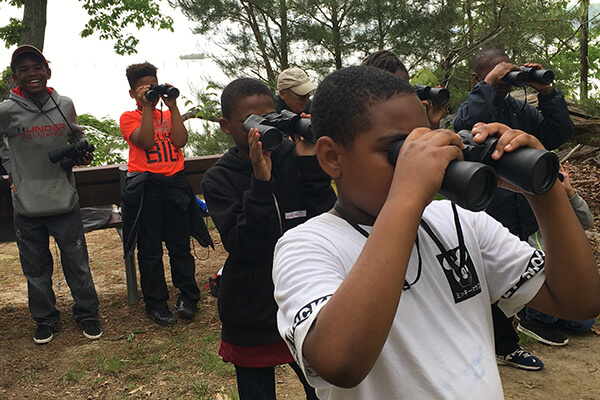 A group of children look through binoculars