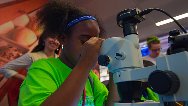 a child looks into a microscope