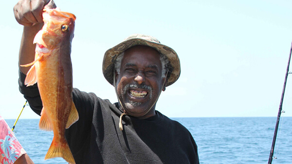 a person holds up a freshly caught fish