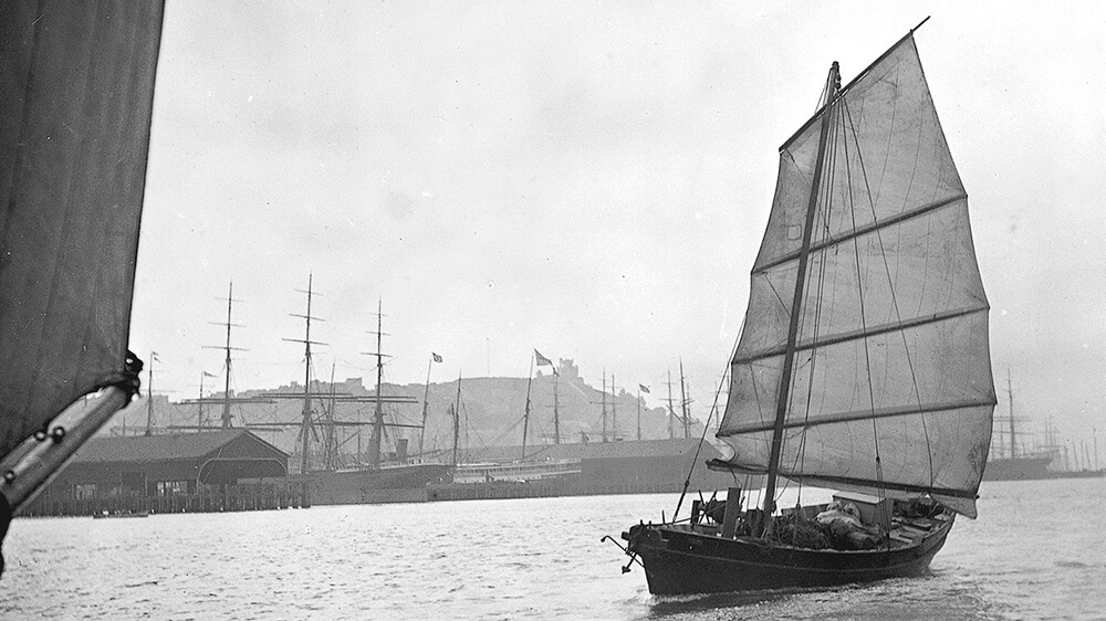 black and white photograph of a sailing vessel with the sail at full mast