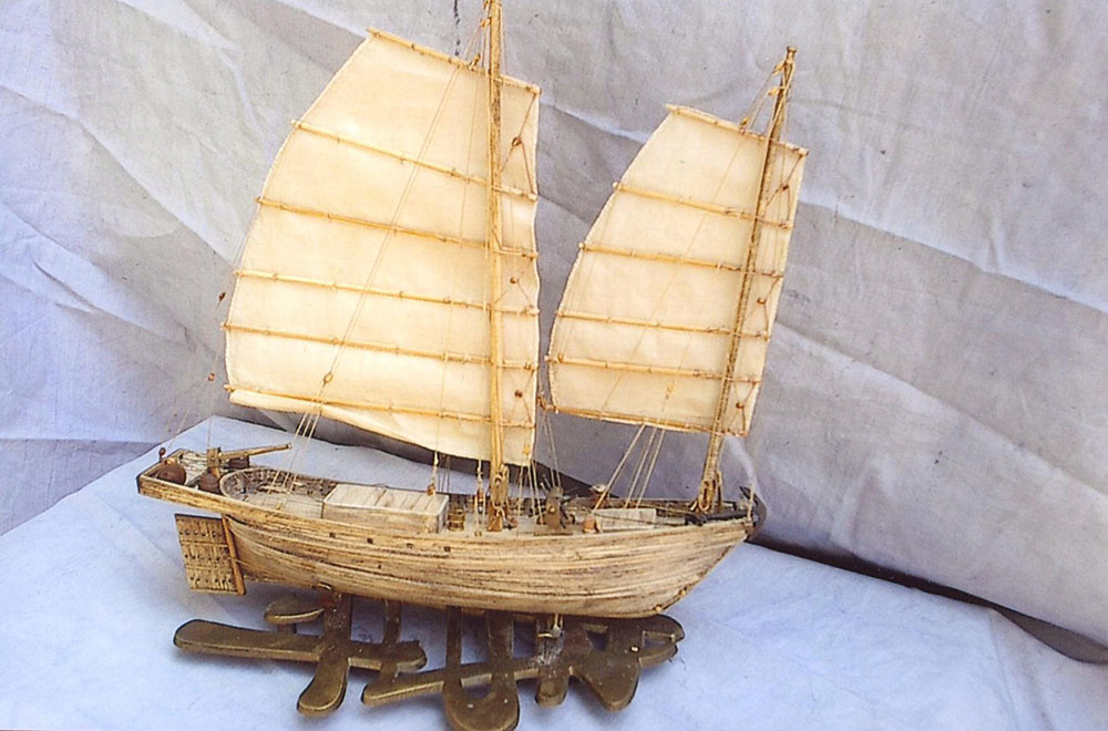 a small model of a wooden sailboat