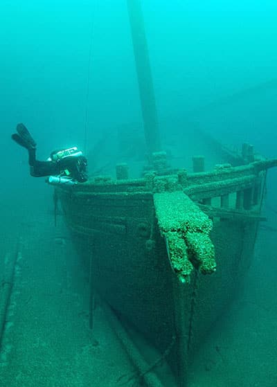 a scuba diver next to a shipwreck