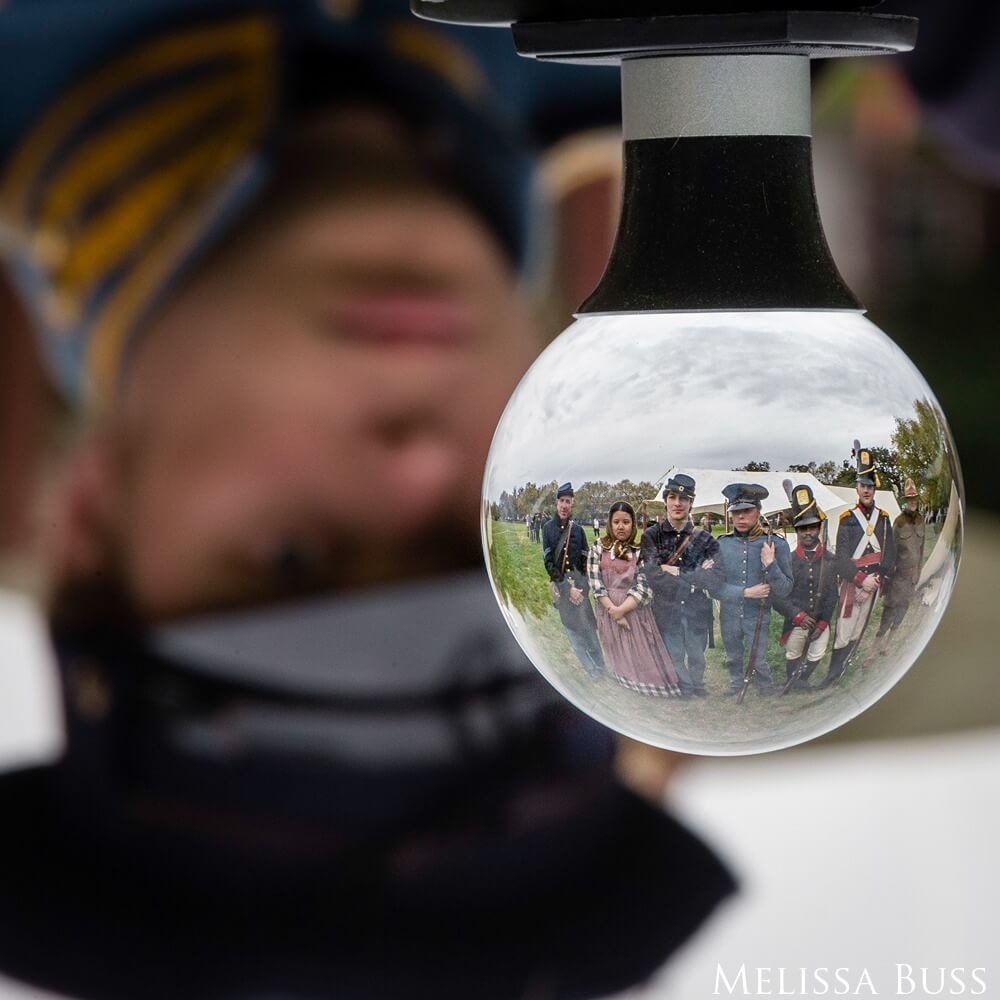 The reflection of a group shows upside down through a glass orb.
