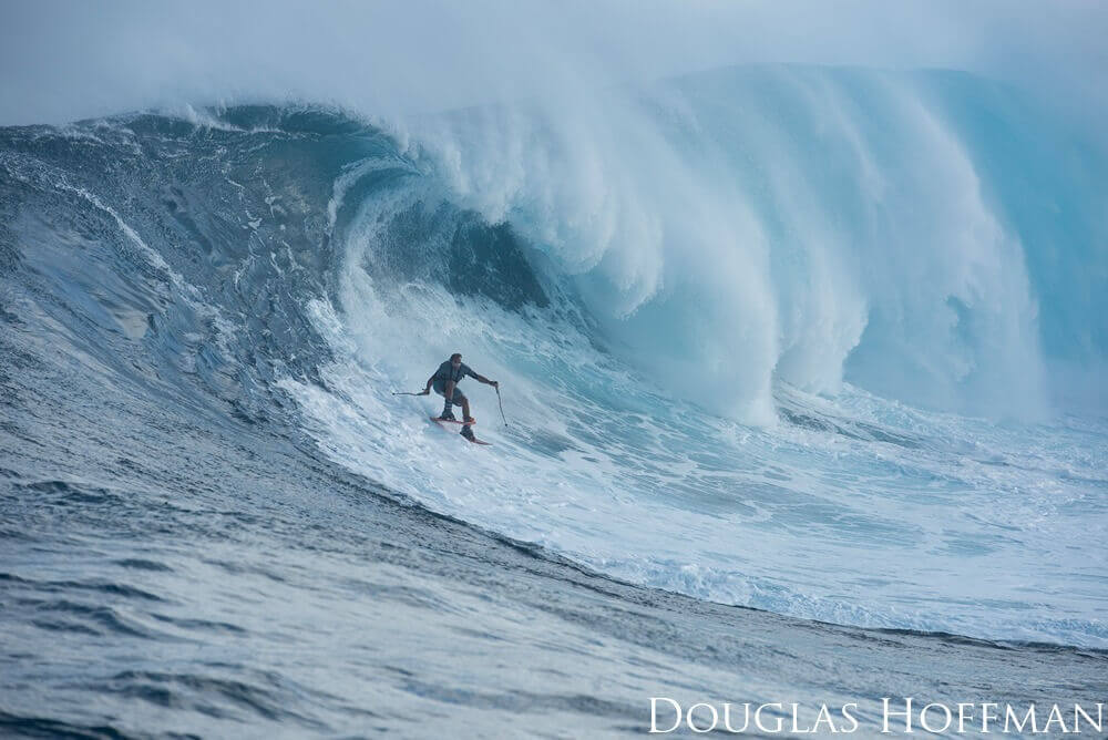 A surfer is seen dropping in on a large wave as it capps over