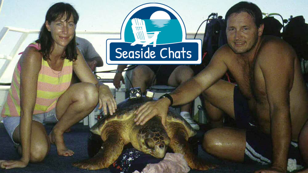 two people on deck with a sea turtle