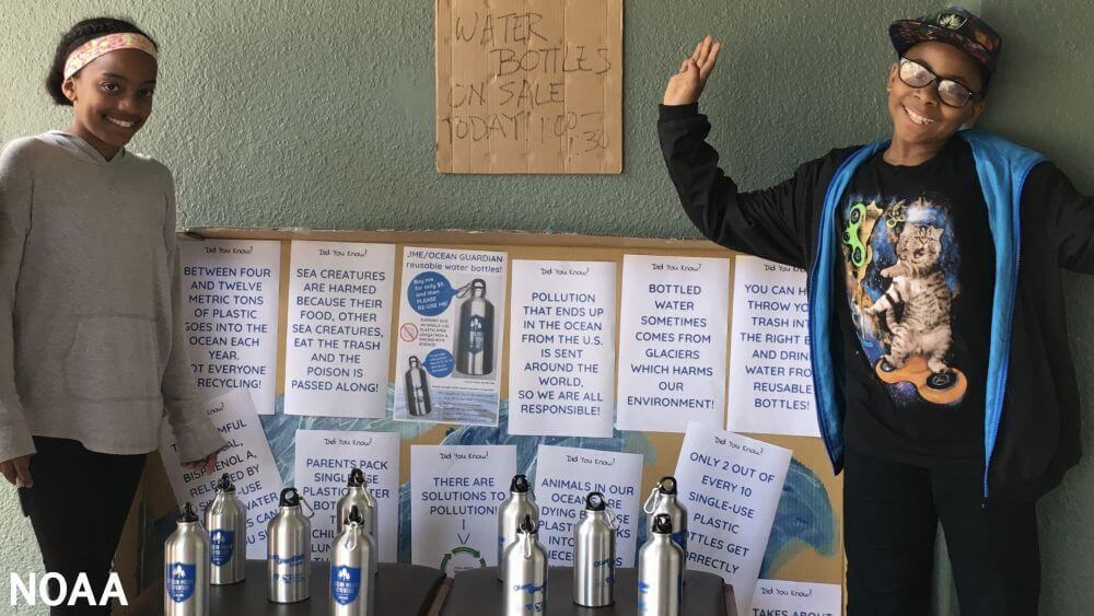 Students at Joaquin Miller Elementary pose with their reusable water bottles and facts about ocean pollution.
