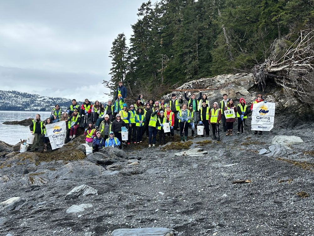 Dimond High School students pose with their waste collection materials during a coastal cleanup in
                            Prince William Sound.