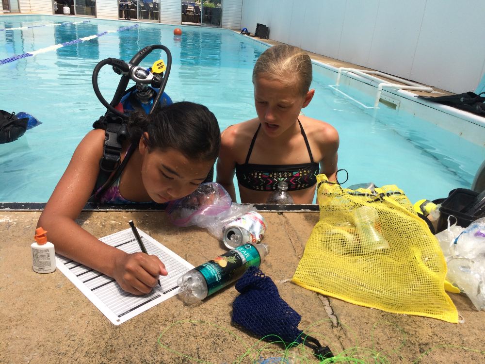 Dive club youth practice diving skills while also gaining experience in conducting an underwater cleanup activity.