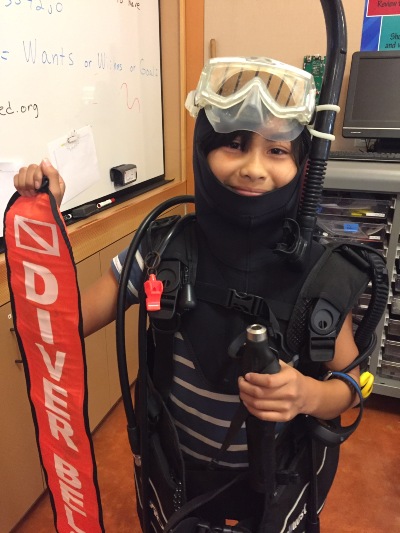 Child wearing scuba diving gear and equipment