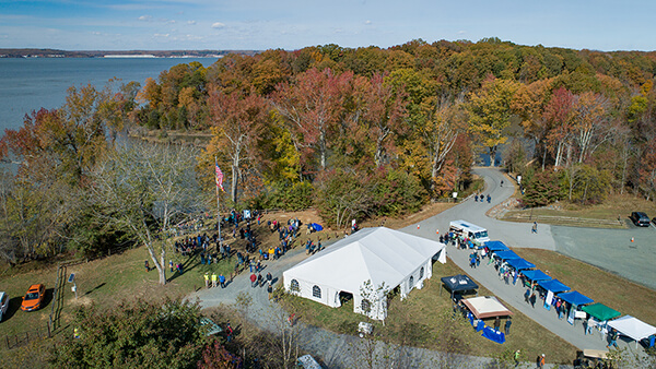 aerial view of a large white event tent near a river