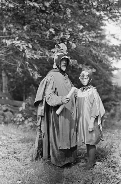 a man and child dressed up as the characters Cardinal Bird and Hummingbird in the forest