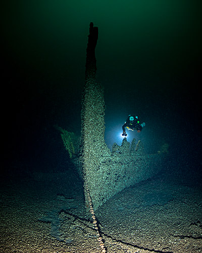 A diver inspects the bow of a shipwreck