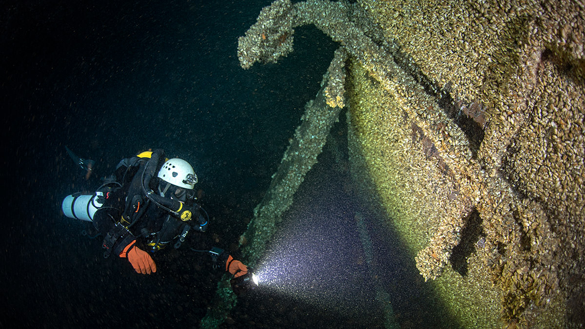 A diver inspects the bow of Queen of the Lakes, where the anchor remains in place