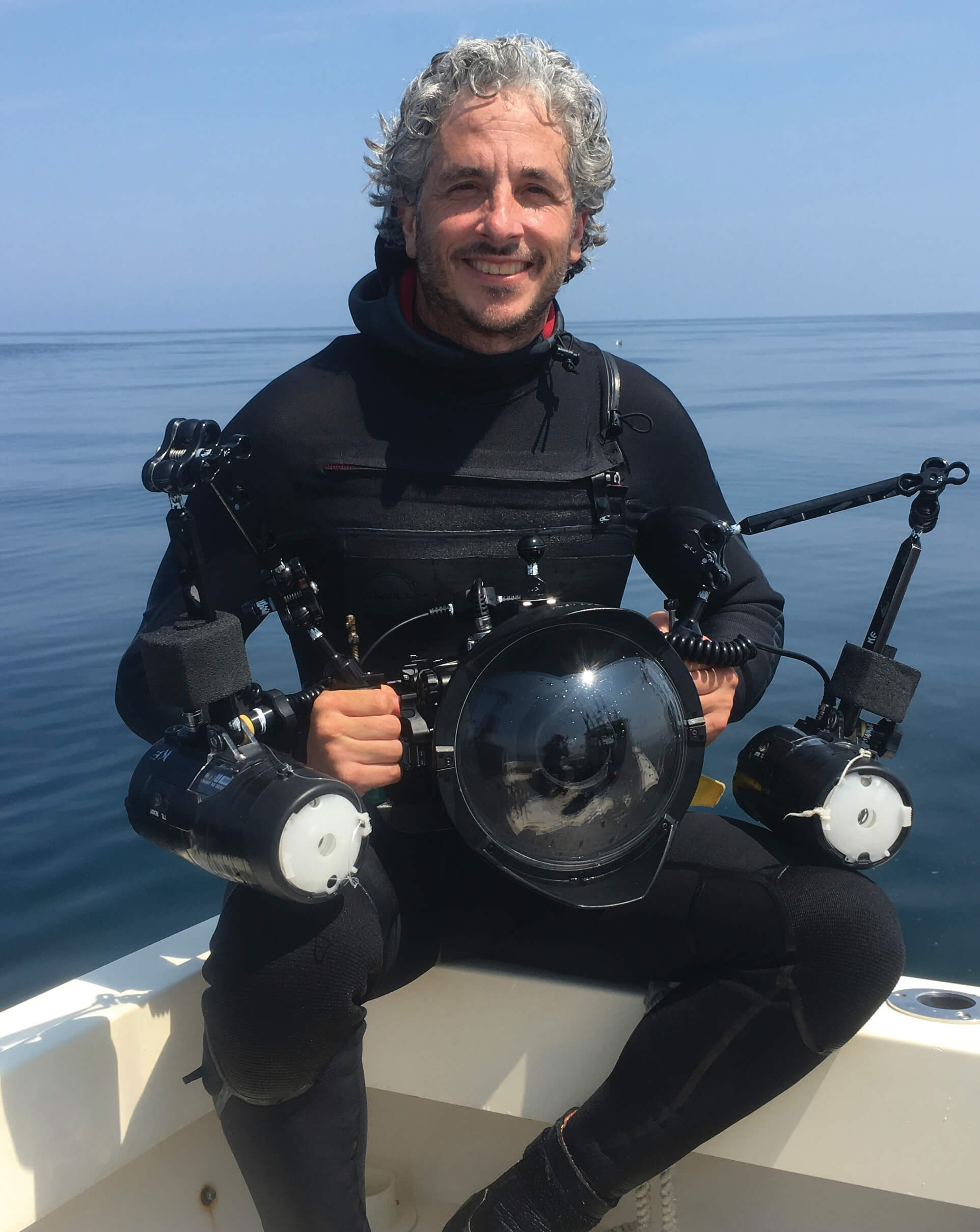 Keith Ellenbogen sitting on the side of a boat in scuba gear