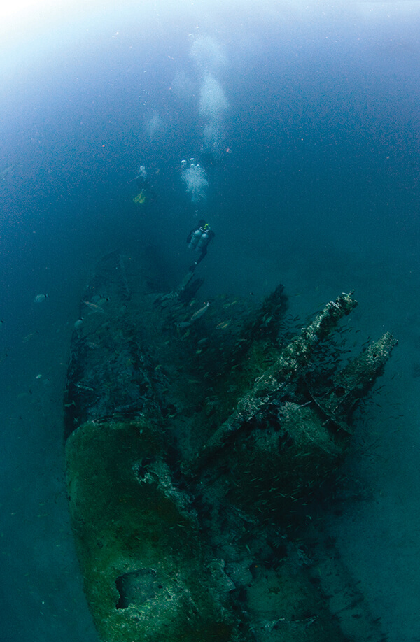 Divers swim above the wreck of a U-boat