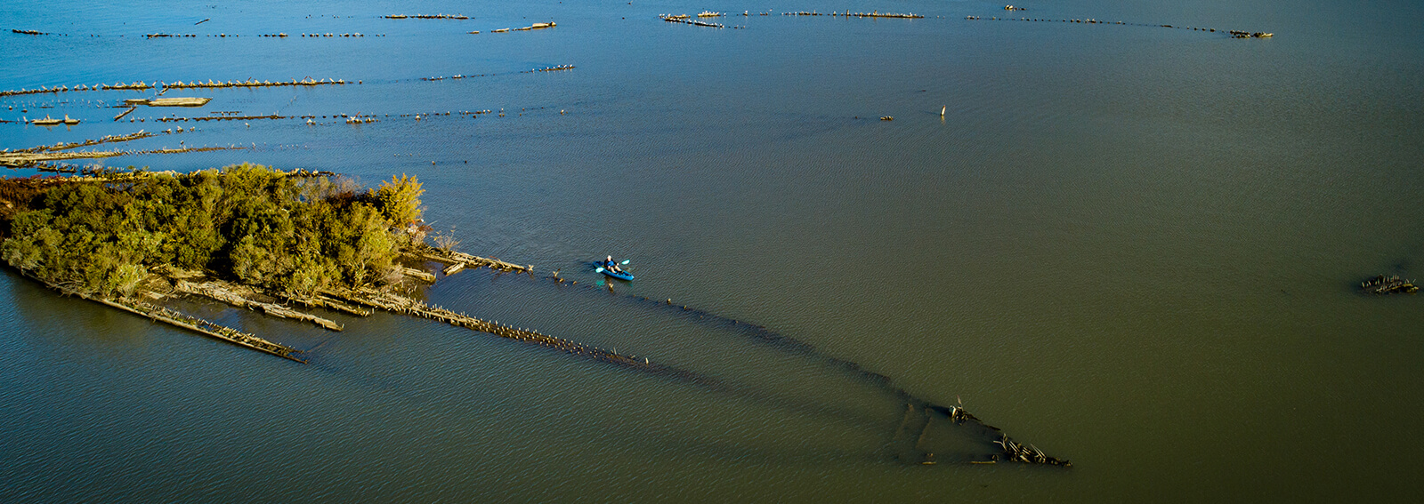a kayaker paddles next to a a shipwreck