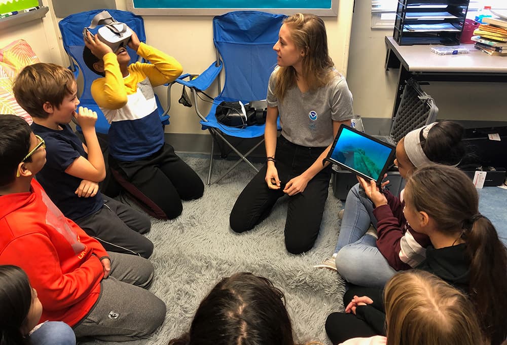 group of kids watching a classmate with a vr headset on