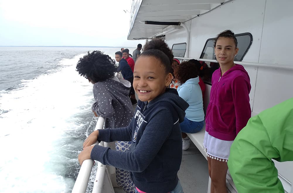 kids on a boat looking for whales