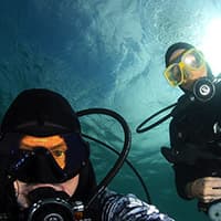 two divers take a selfie underwater