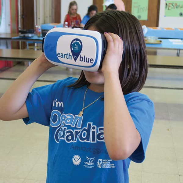 child holding a VR headset to their face