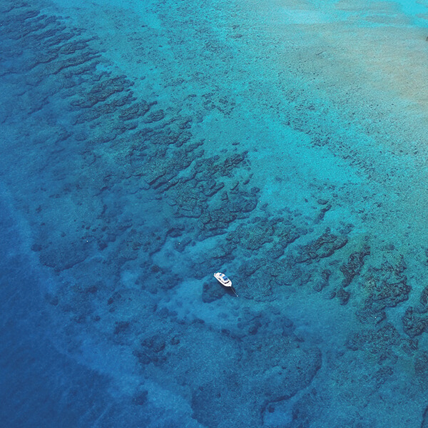 A boat floats above a barrier reef