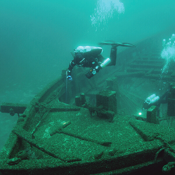 a diver swims above a sipwreck