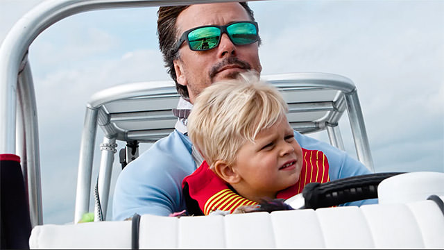 will benson with his son driving a boat