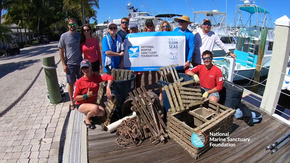 A group of people pose with marine debris they cleaned up