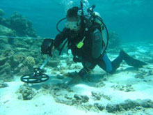 archaeologists use a metal detector underwater