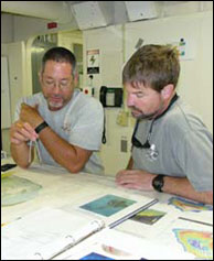 Maritime Archaeologists Hans Van Tilburg and Bob Schwemmer review charts of Kure Atoll during transit up the NWHI chain