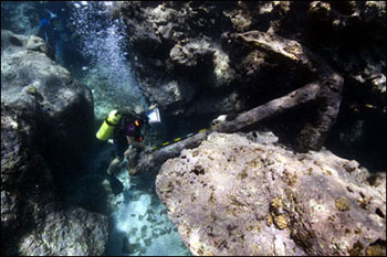 Diver investigates an anchor on the shipwreck site Gledstanes at Kure Atoll
