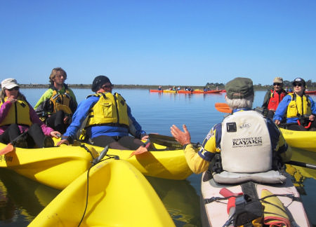 Volunteer in kayaks recieving instructions