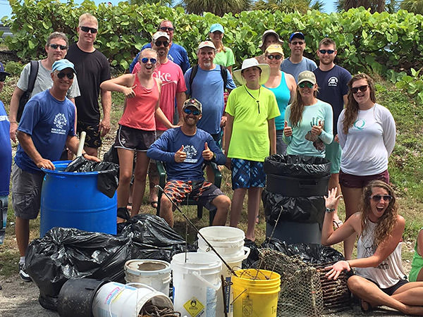 volunteers posing infront of the marine debris they collected