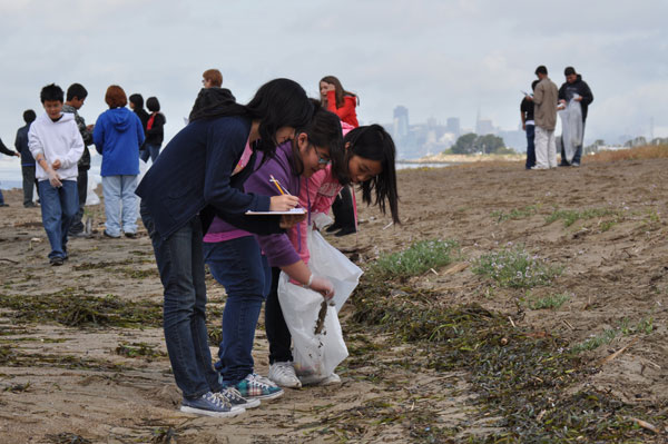 Class of kids cleaning up a beach