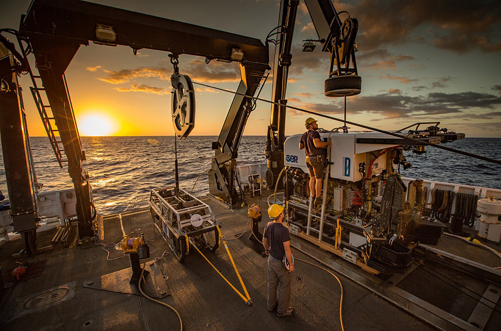 two memeber of the okeanos crew prepare an rov on deck