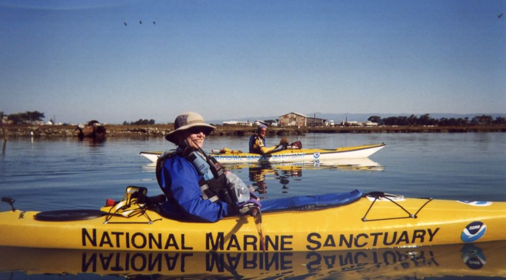 two volunteers in kayaks looking for marine debris